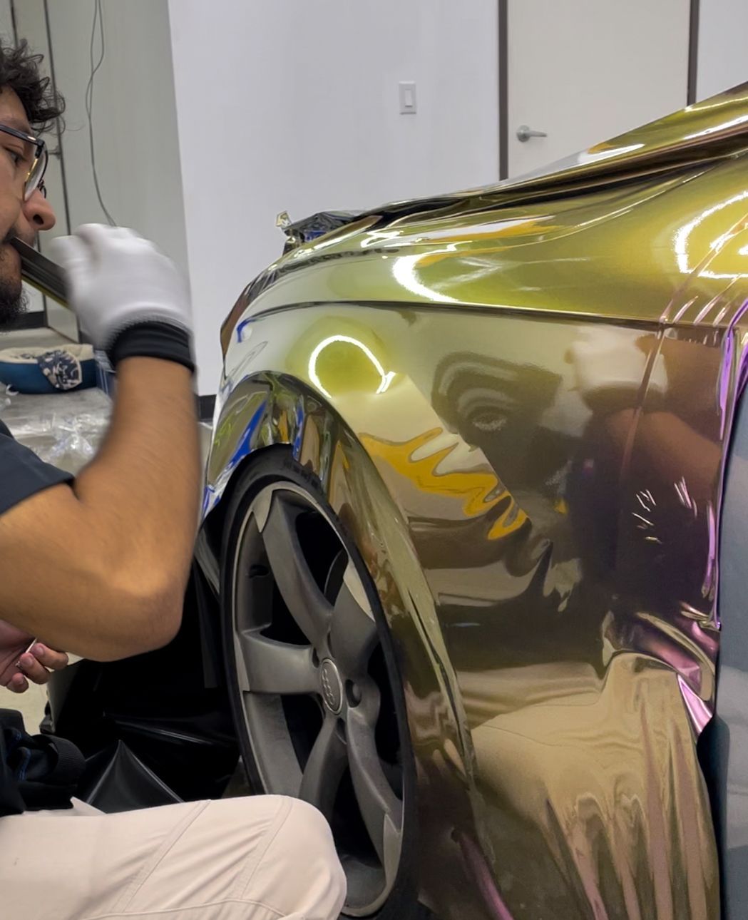 A man is wrapping a car with purple tape