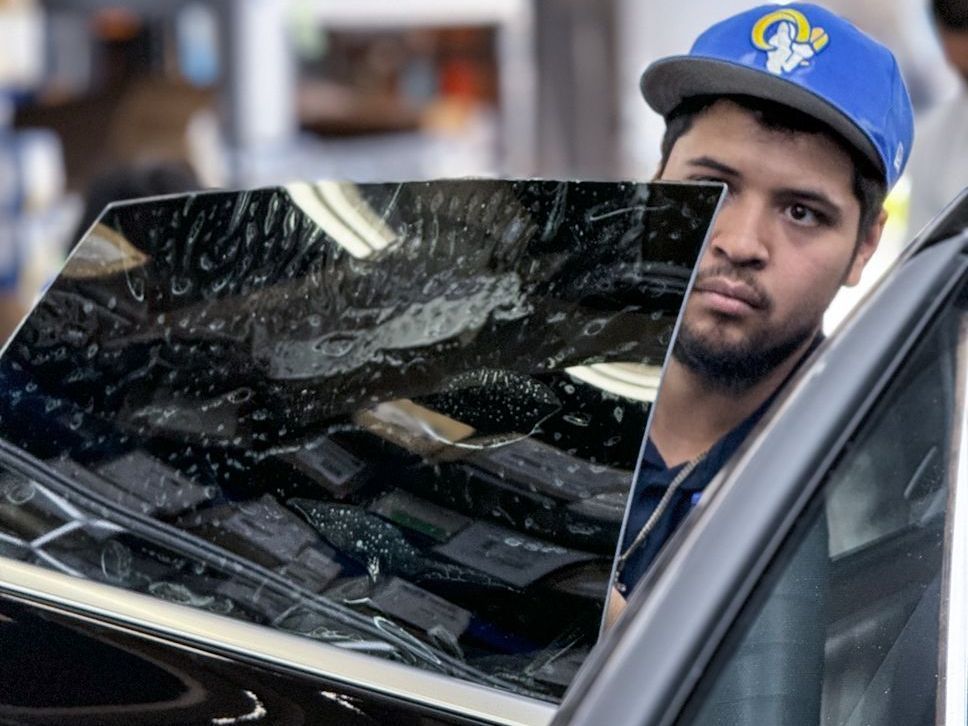 A man wearing a blue hat is looking out of a car window.