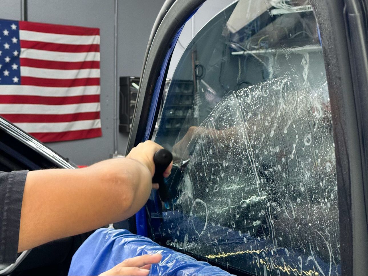 A person is applying window tinting to a car window.