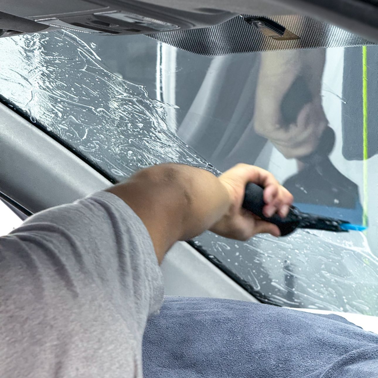 A person is putting a piece of film on a window