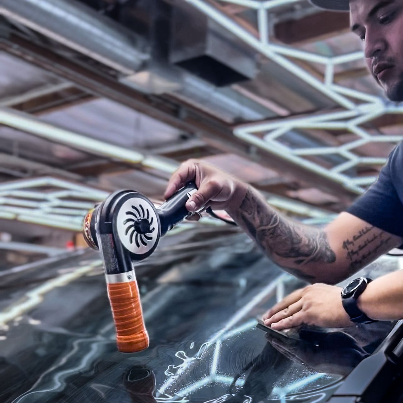 A person is cleaning a car windshield with a brush