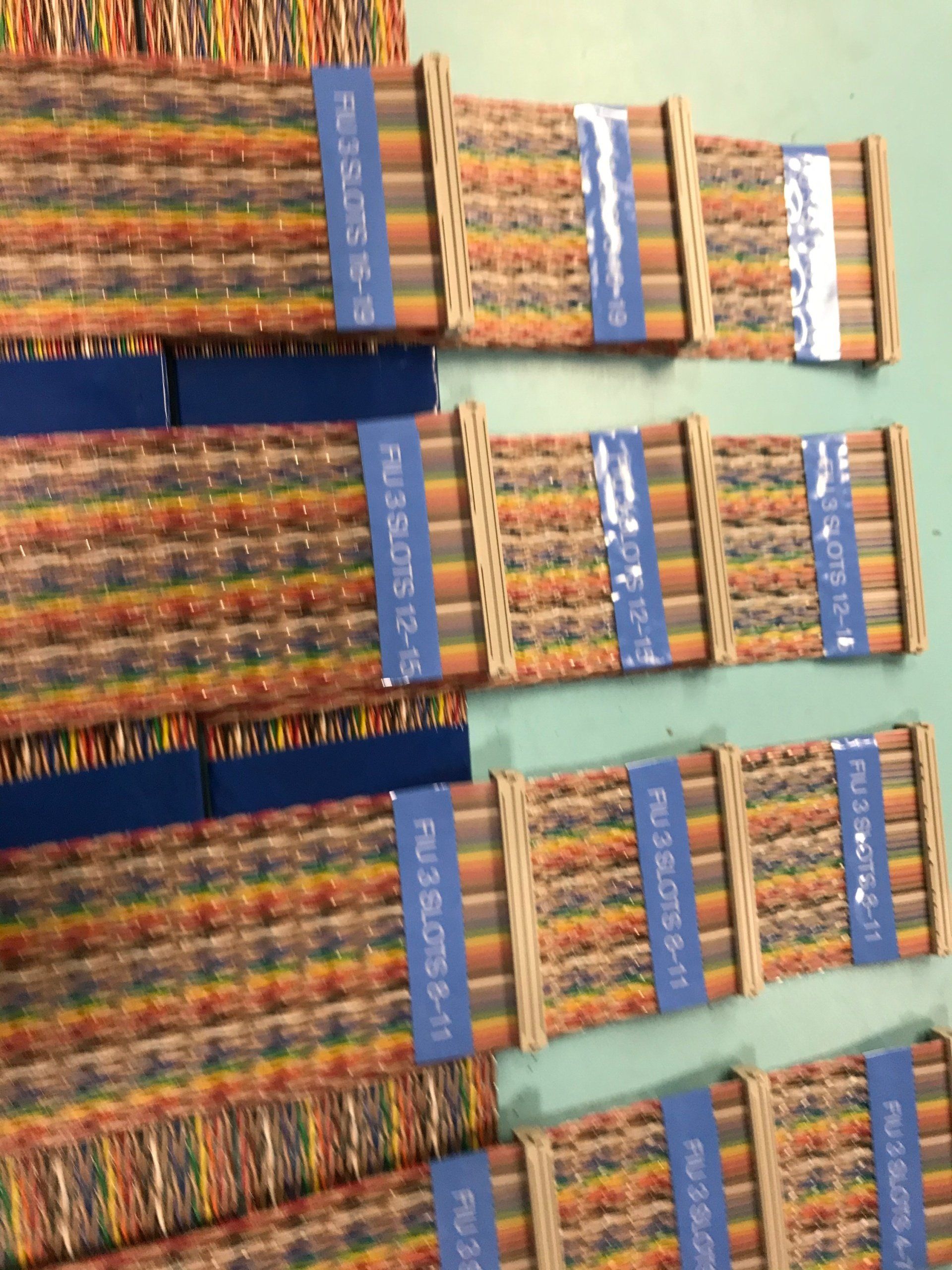 A bunch of colored pencils are stacked on top of each other on a table.