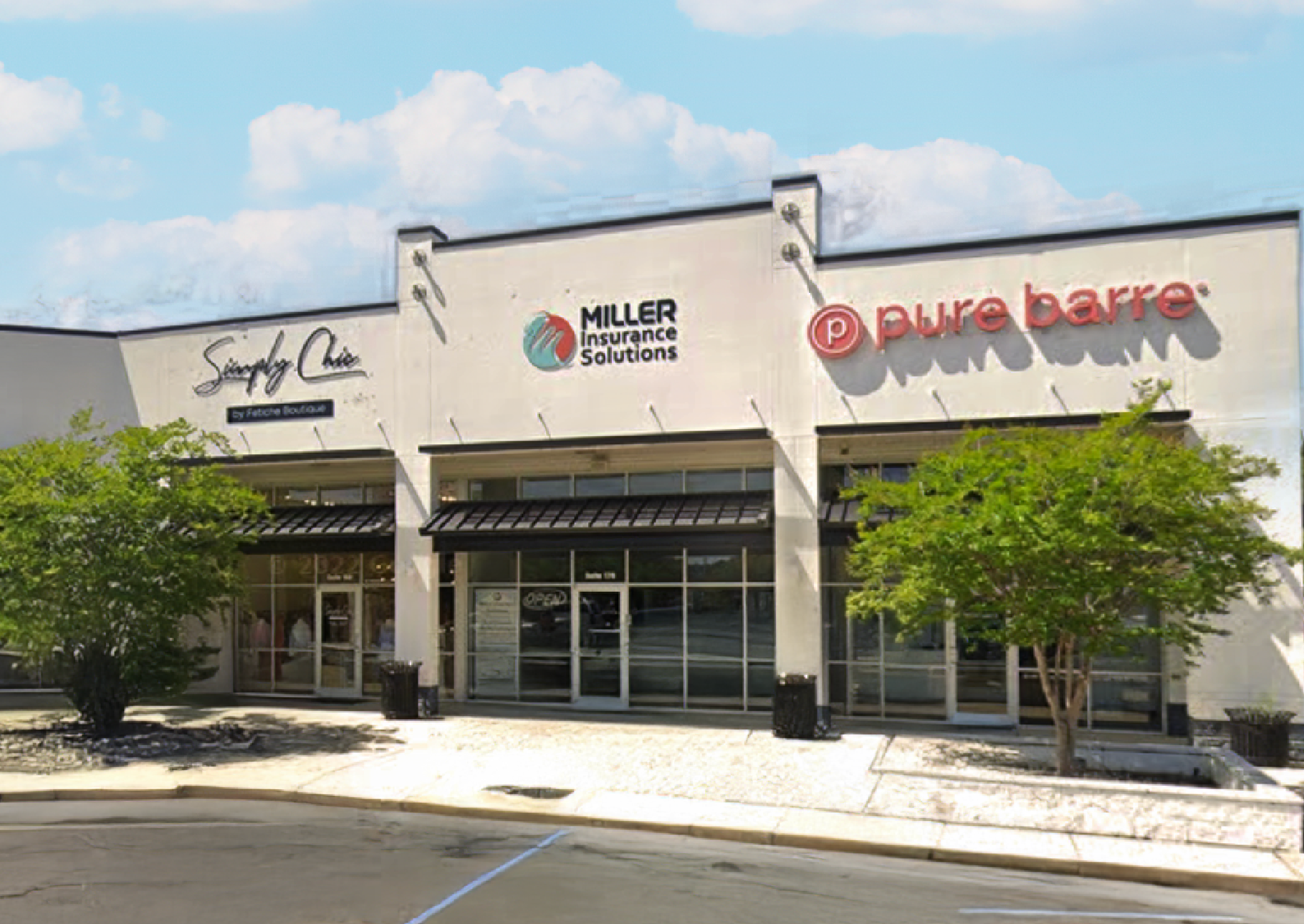 A young boy with down syndrome is smiling for the camera while sitting in a wheelchair.