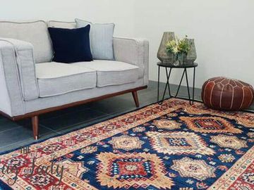 A living room with a couch and a rug