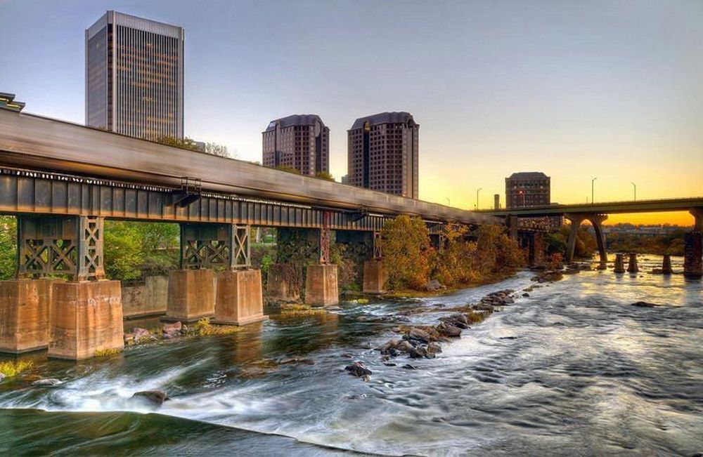 A bridge over a river with a city in the background.