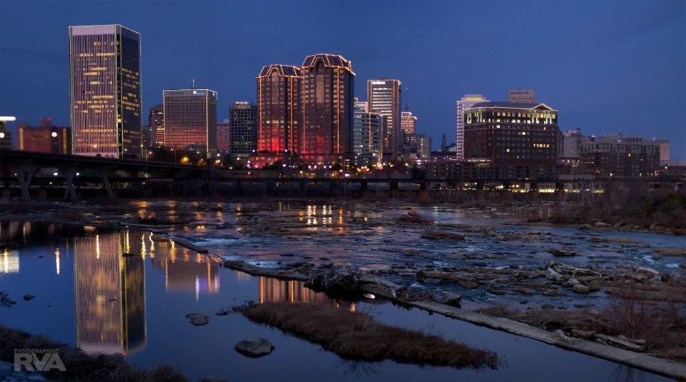 A city skyline is reflected in a body of water
