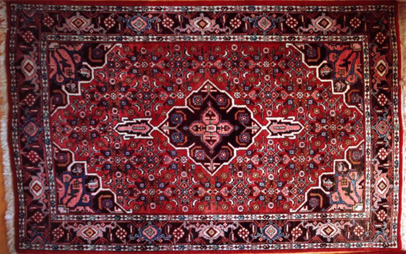 A red rug with a floral pattern on it