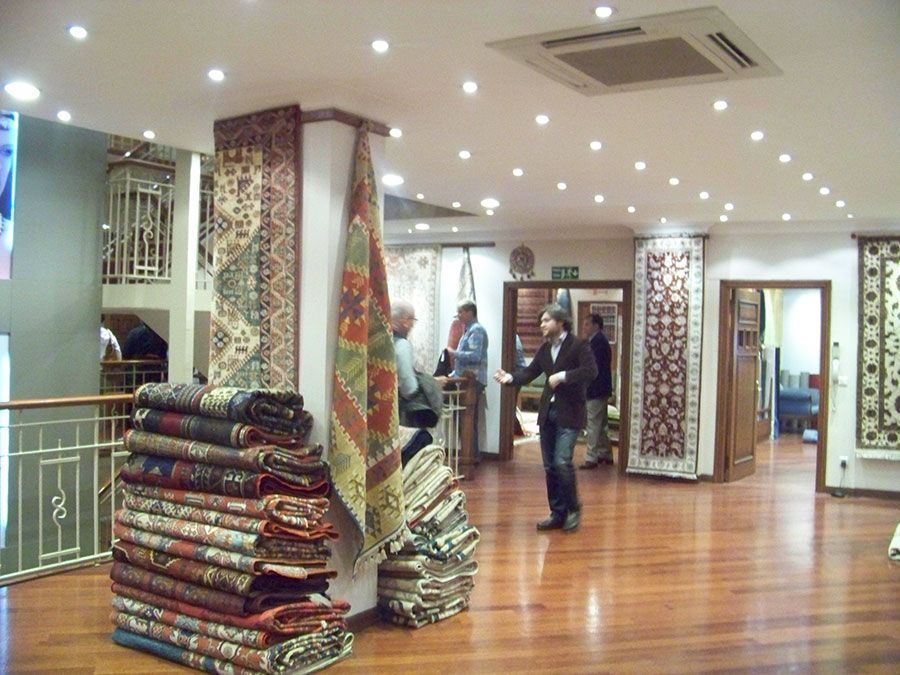 A group of people standing around a stack of rugs