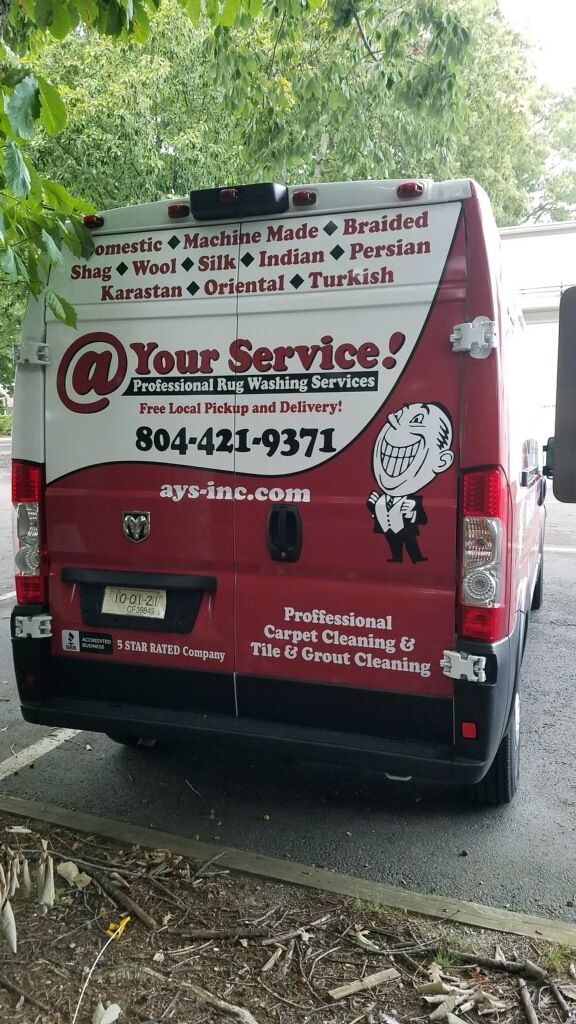 A red van with a cartoon man on the back is parked in a parking lot.
