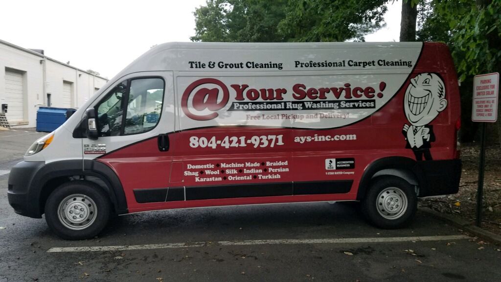 A red and white van for your service is parked in a parking lot