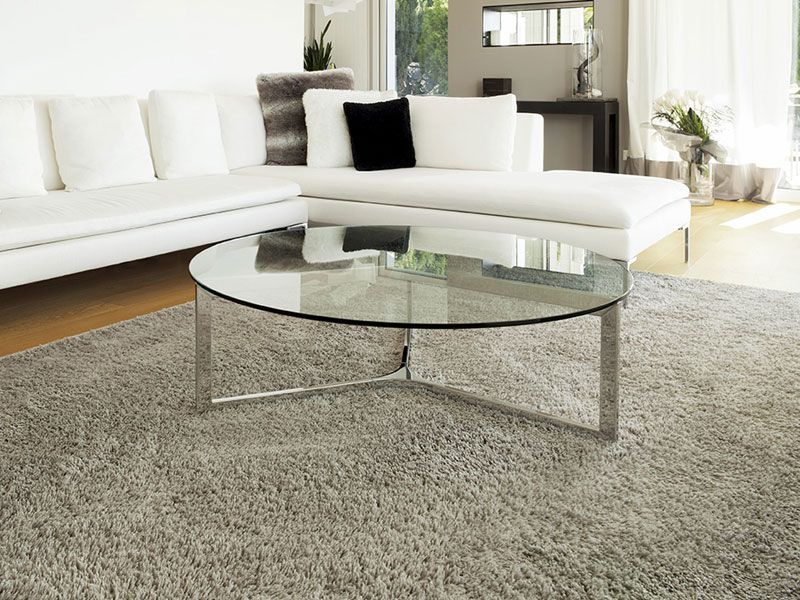 A living room with a white couch and a glass coffee table