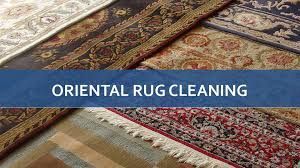 A group of oriental rug cleaning rugs sitting on top of each other on a floor.