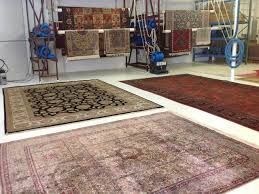 A room filled with lots of rugs and a vacuum cleaner.