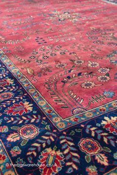 A close up of a pink and blue rug with flowers on it.