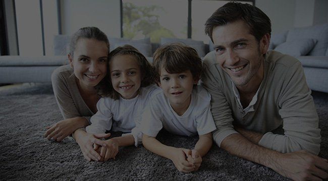 A family is laying on the floor in a living room.