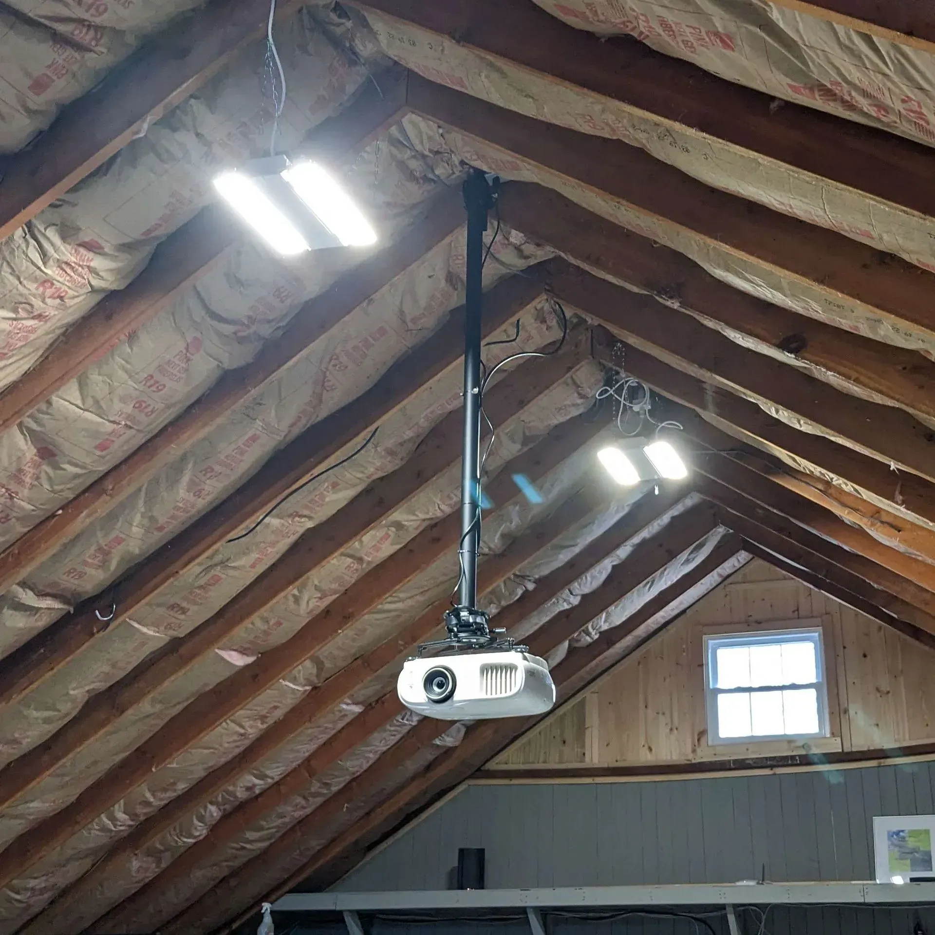 An attic with a projector hanging from the ceiling