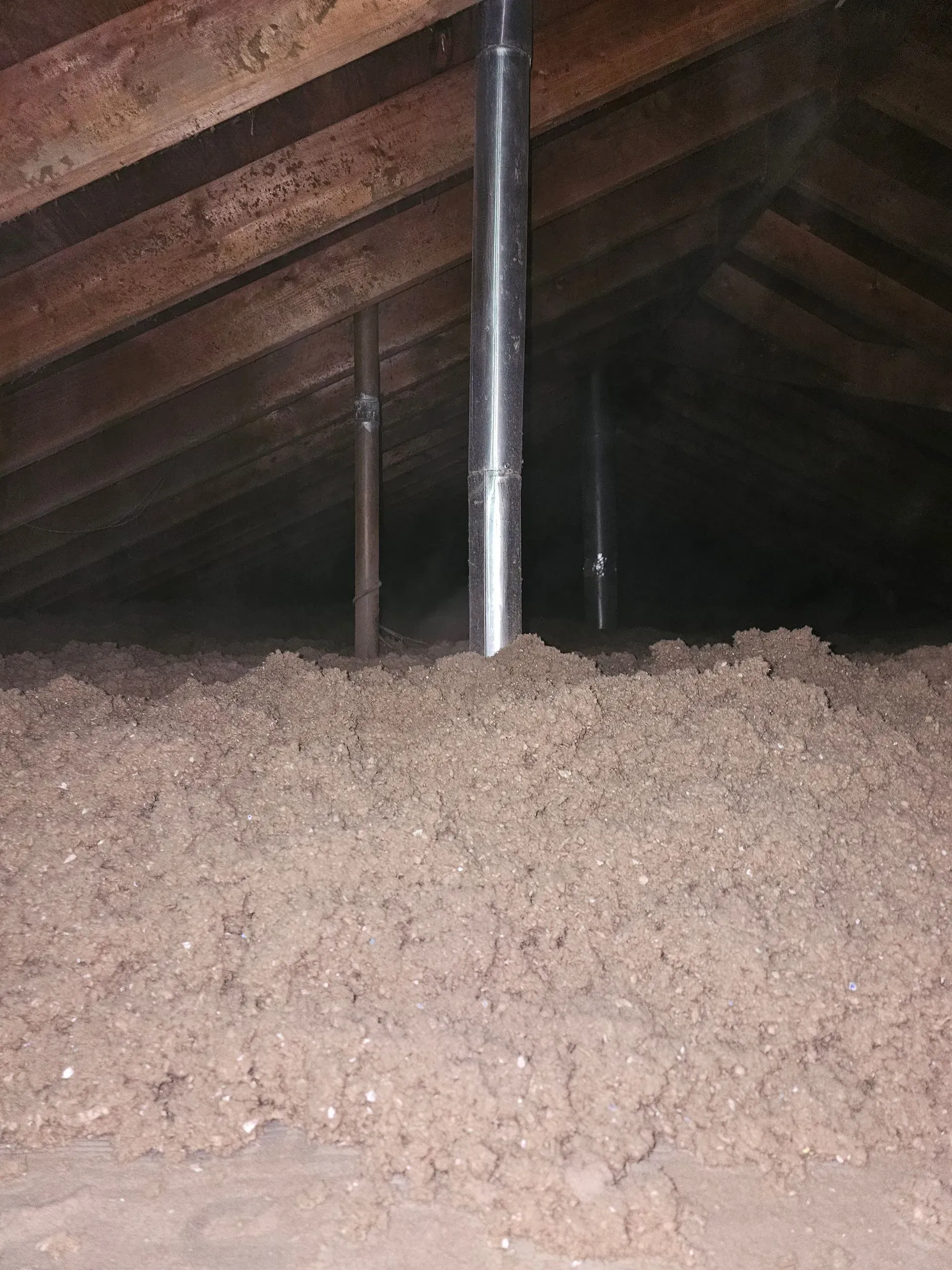 A pile of insulation in the attic of a house