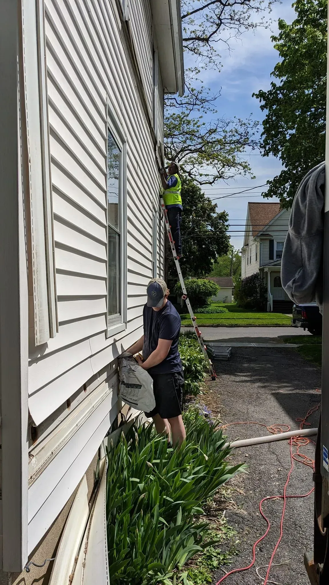 A man is working on the side of a house.