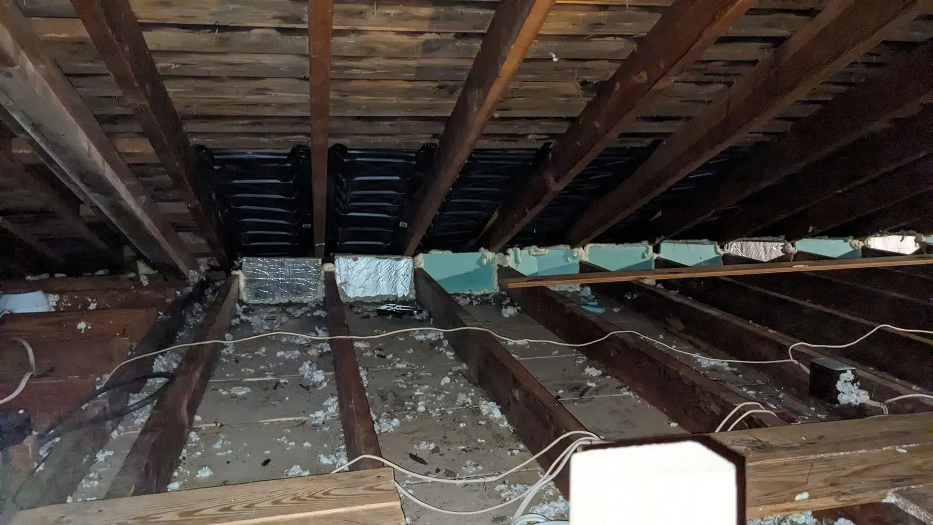 Looking up at the ceiling of a building with wooden beams.