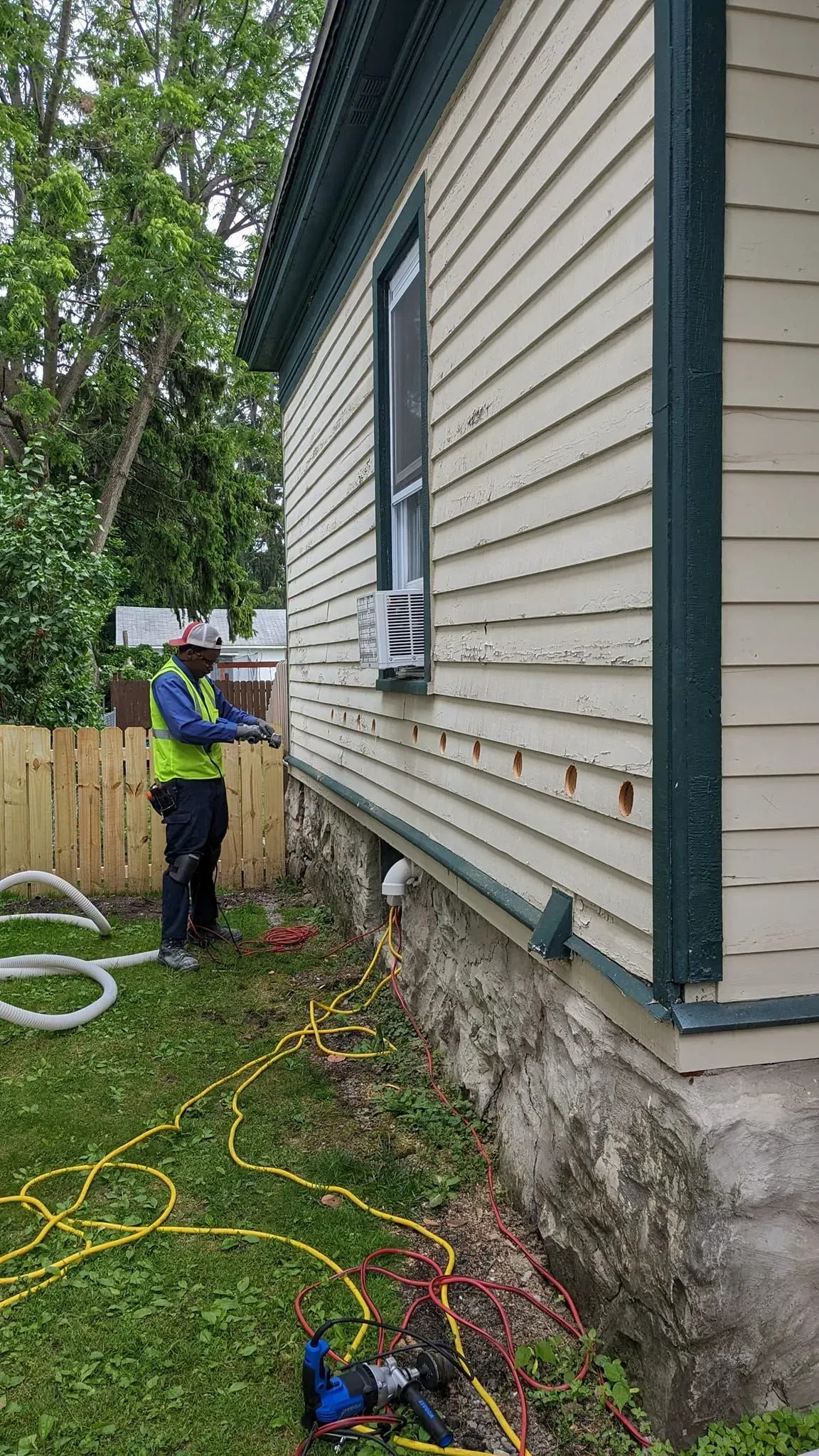 A man is working on the side of a house.