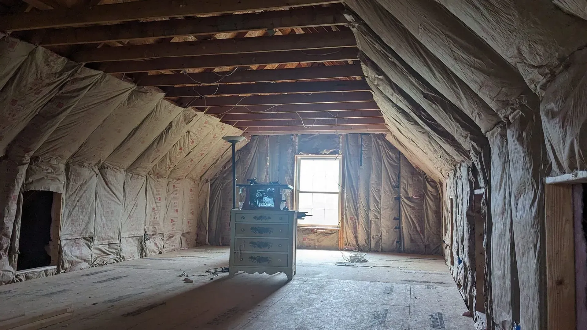 An attic with a lot of insulation on the walls and ceiling