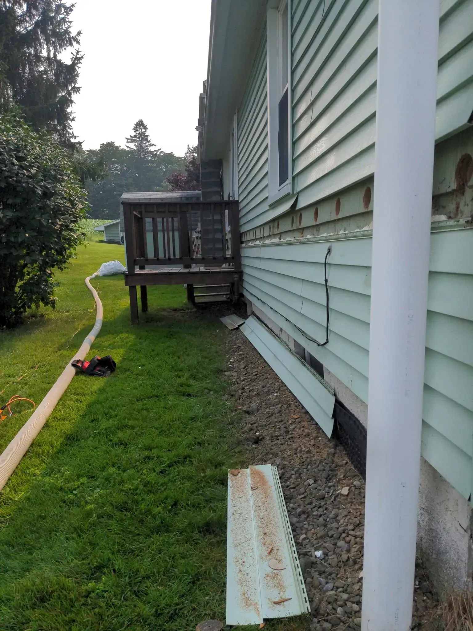 The side of a house with a deck in the backyard.
