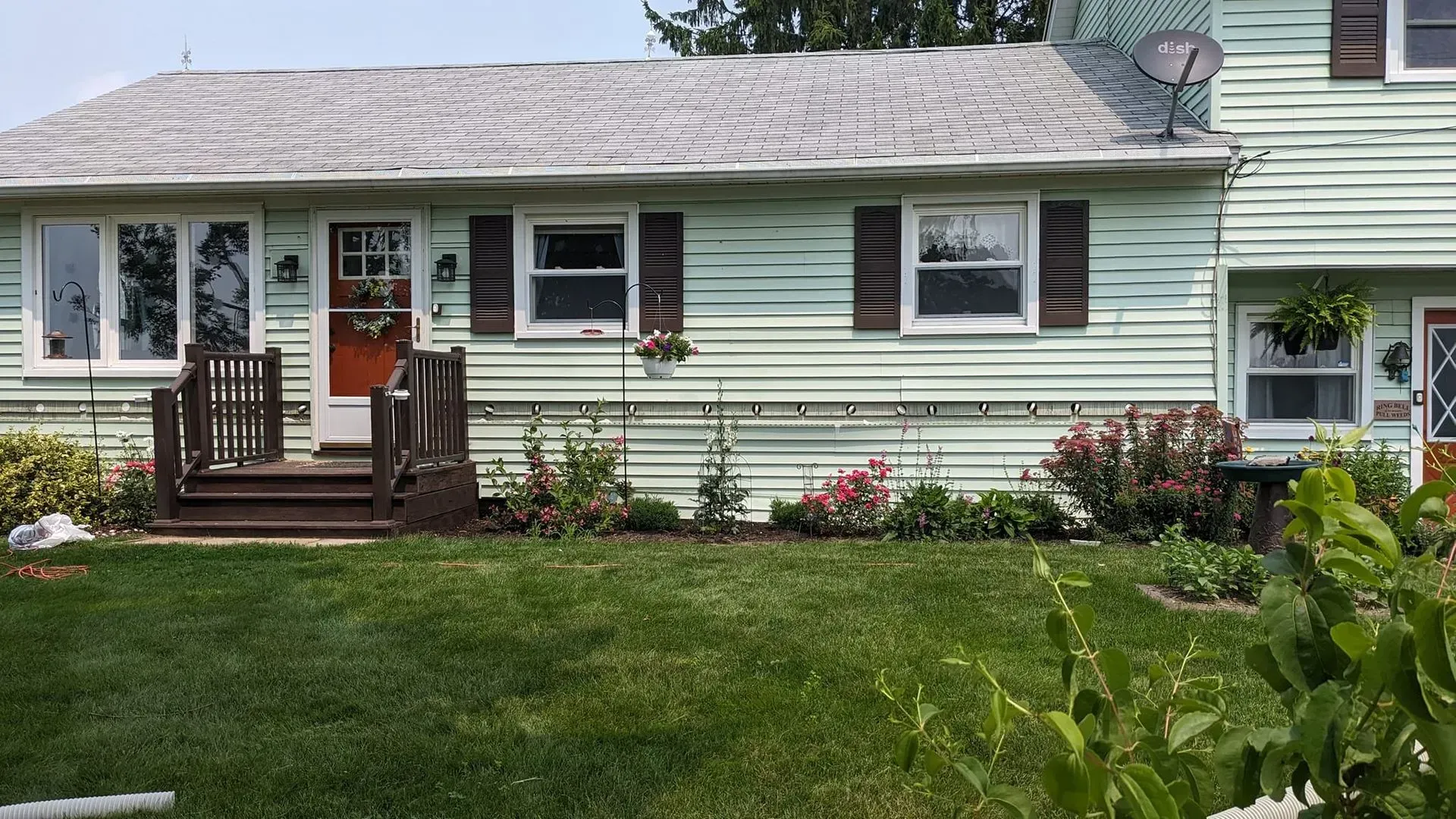 A house with a large lawn in front of it and a satellite dish on the roof.