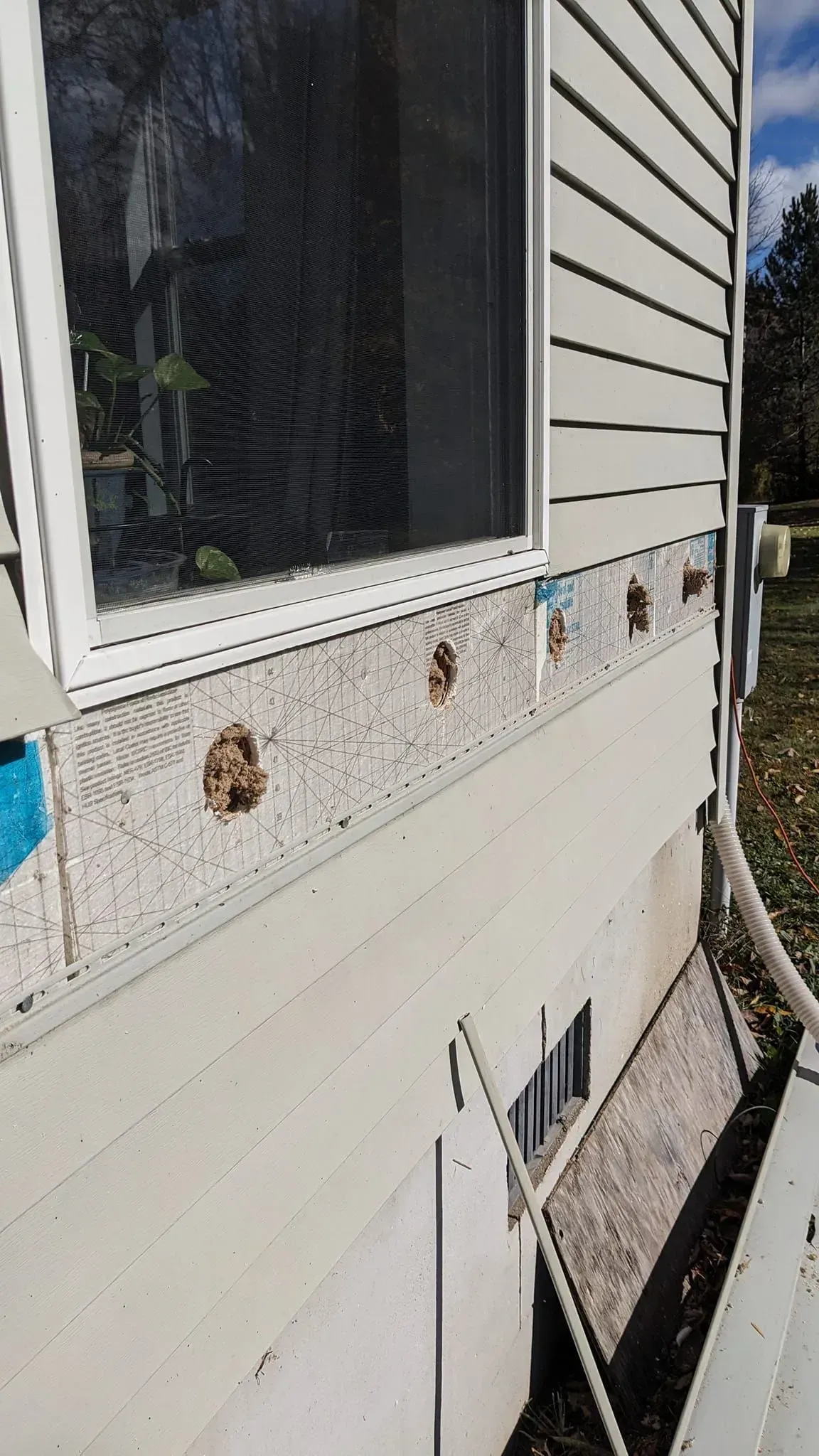 A white house with a window on the side of it.