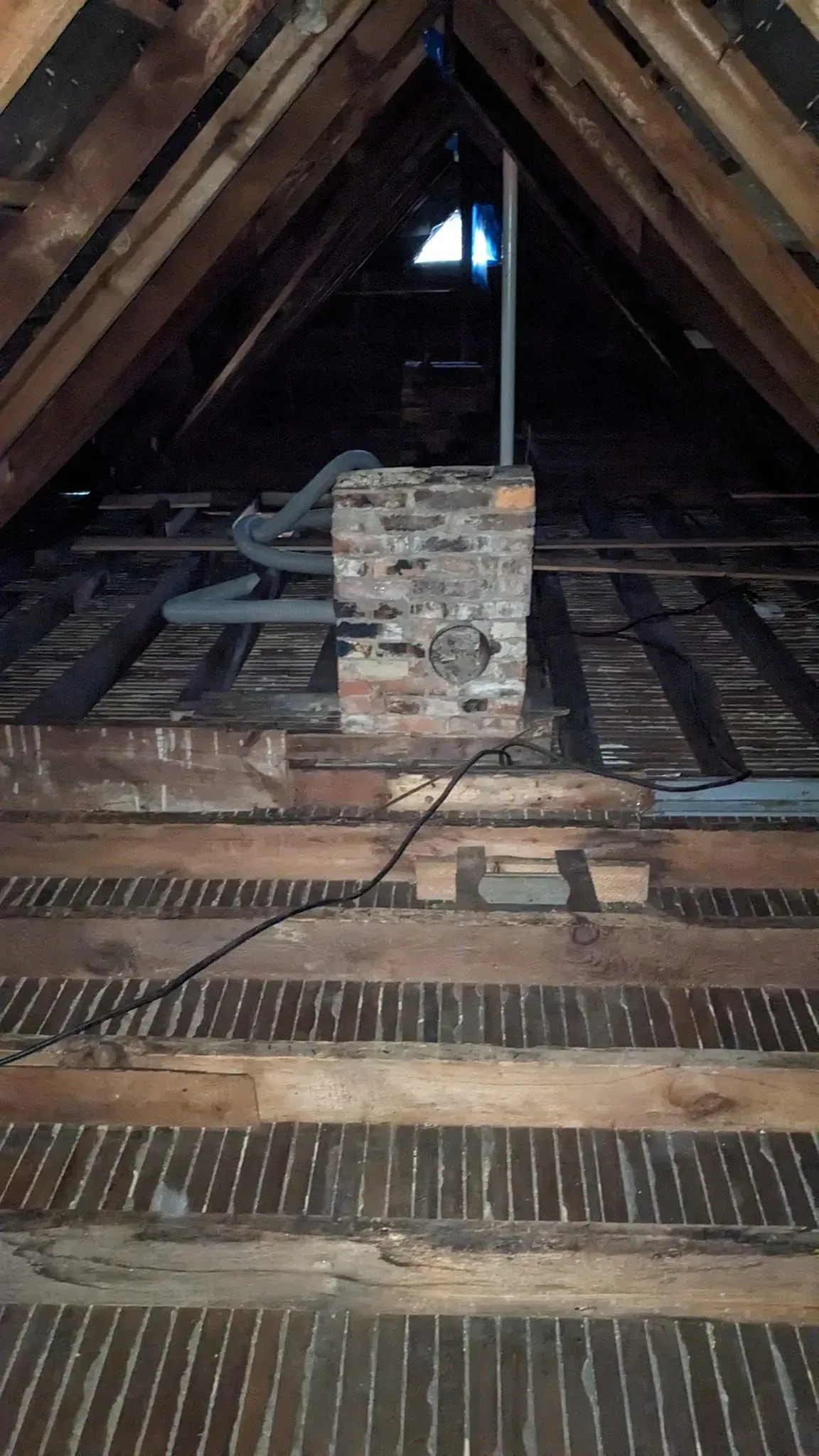 There is a chimney in the attic of a house.