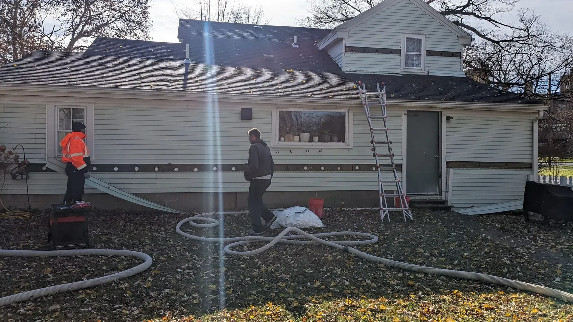 A group of people are standing in front of a house.