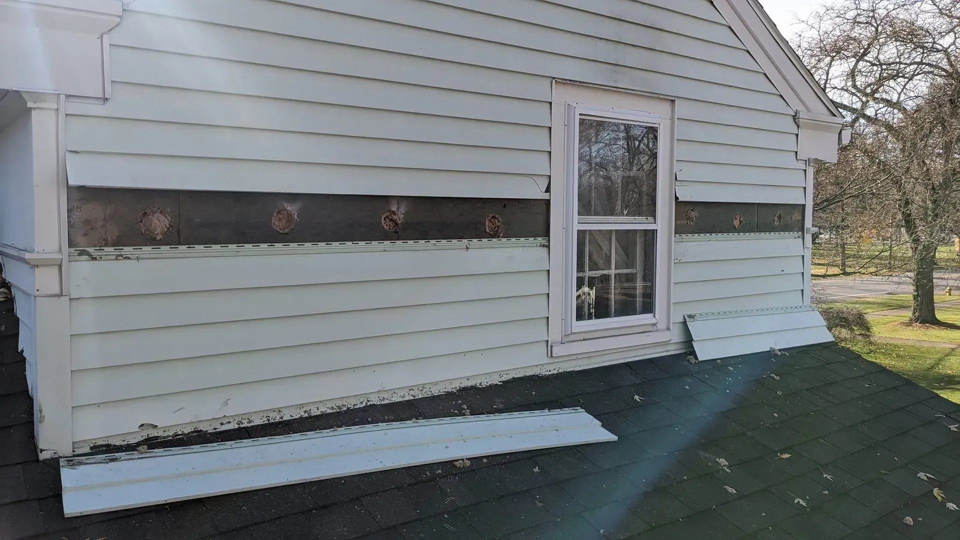 A white house with a window on the side of it.