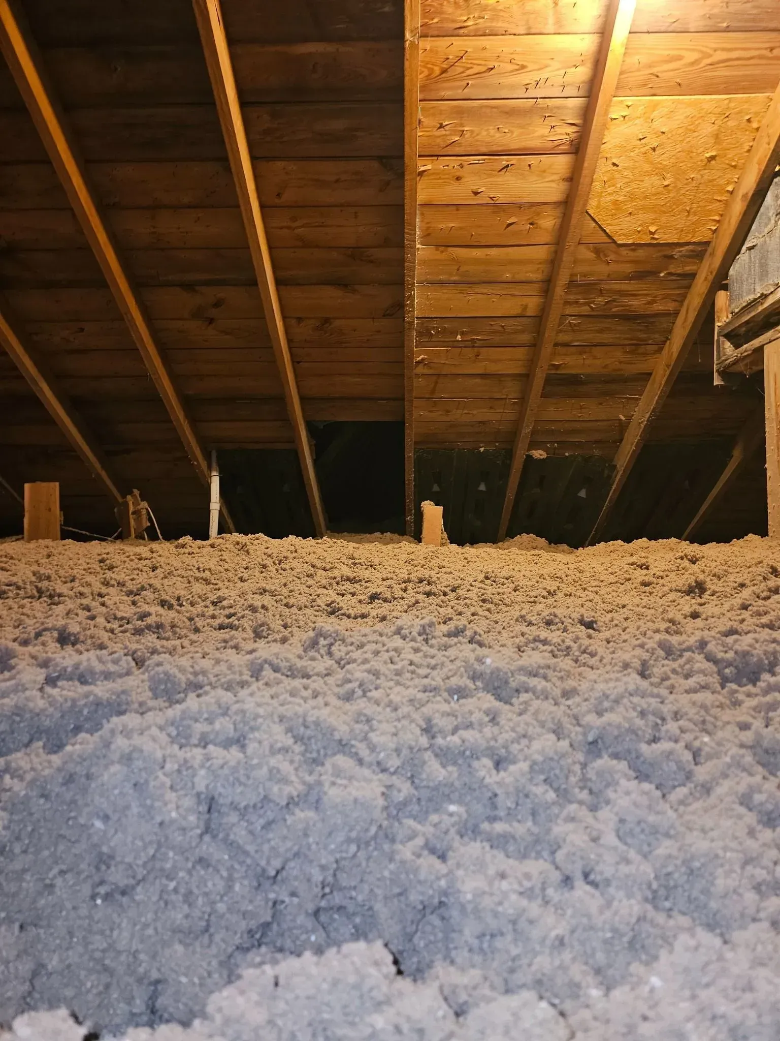 There is a lot of insulation in the attic of a house.