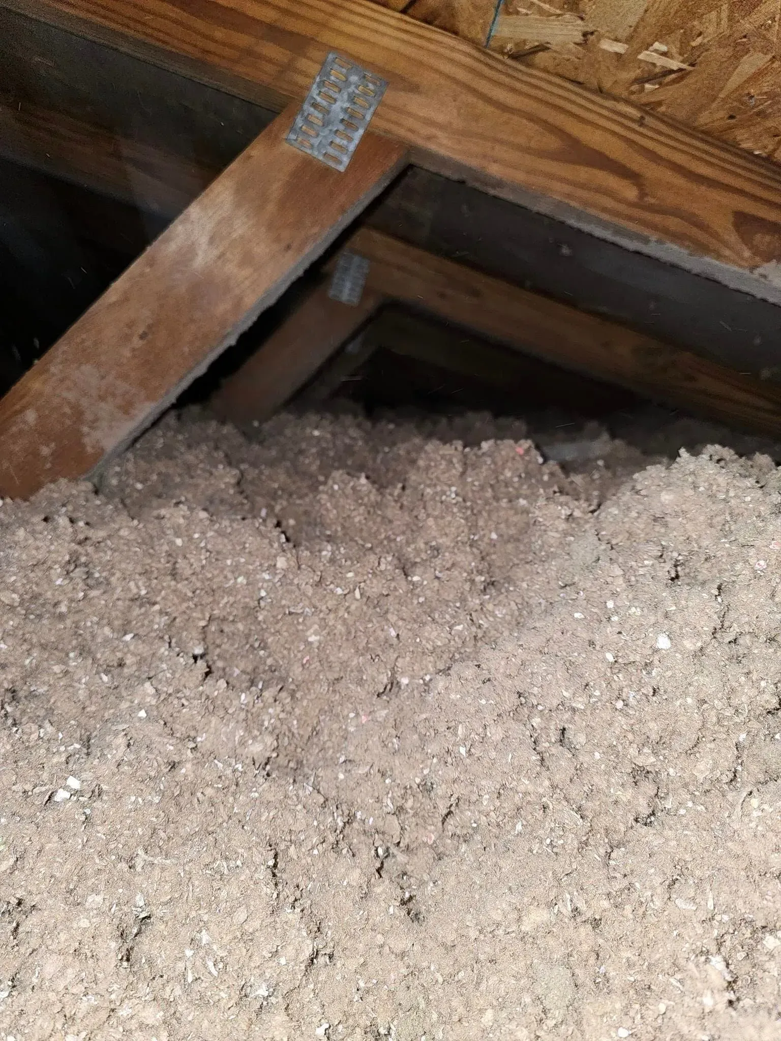 There is a lot of insulation in the attic of a house.