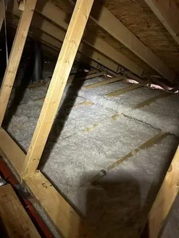 There is a lot of insulation in the attic of a house.