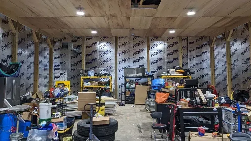 A garage filled with lots of tools and tires.
