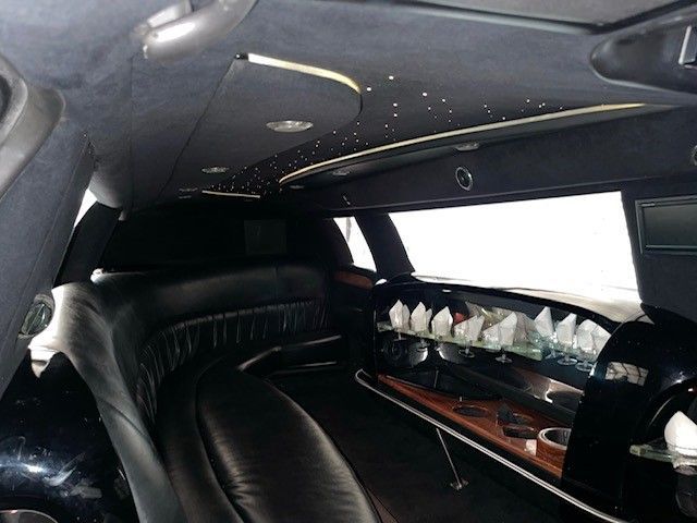 The inside of a black limousine with a long table