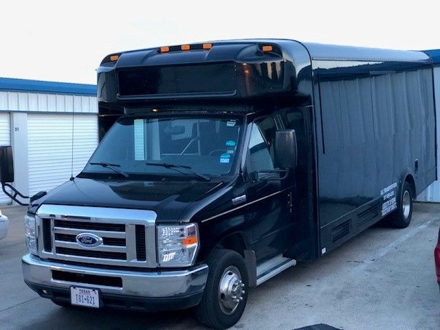 A black ford van is parked in a parking lot