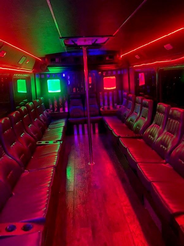 The inside of a bus with red , green , and blue lights.