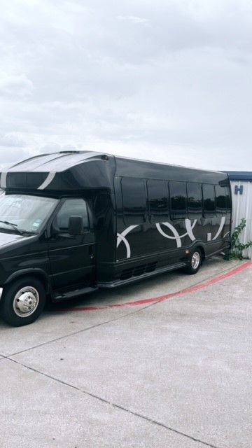 A black and white bus is parked in a parking lot.