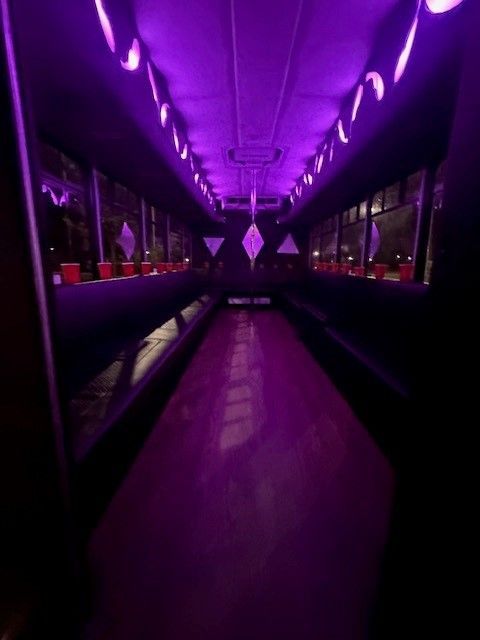 A dark hallway with purple lights on the ceiling