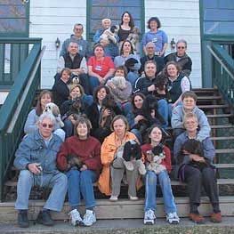Group of people on steps with many dogs.