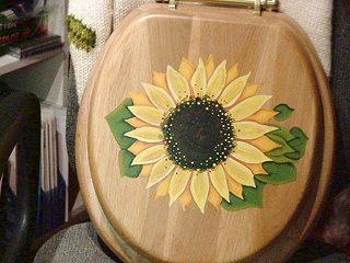 Wooden toilet seat with painted sunflower design.