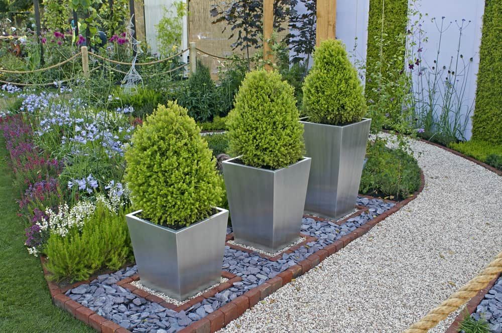 Three Potted Plants Are Sitting On A Gravel Path In A Garden — Pigot's Mid Western Sand and Soil In Orange, NSW