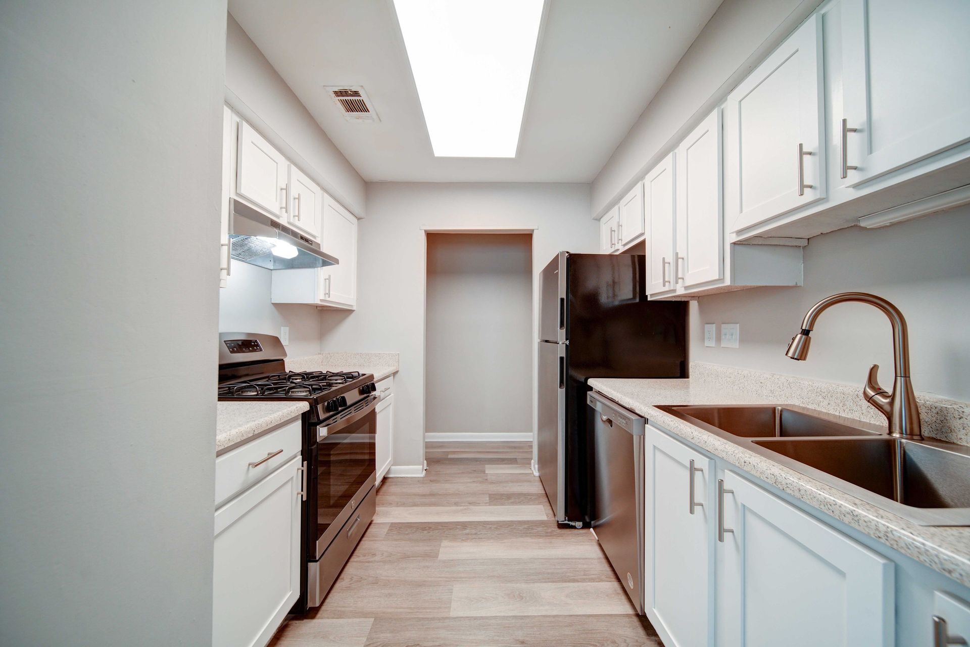 A kitchen with white cabinets and stainless steel appliances