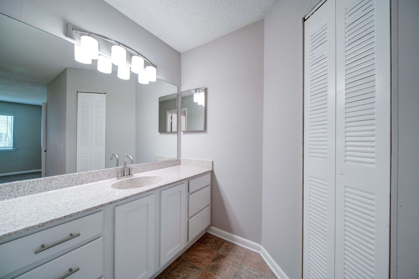 A bathroom with two sinks , a mirror and a closet.