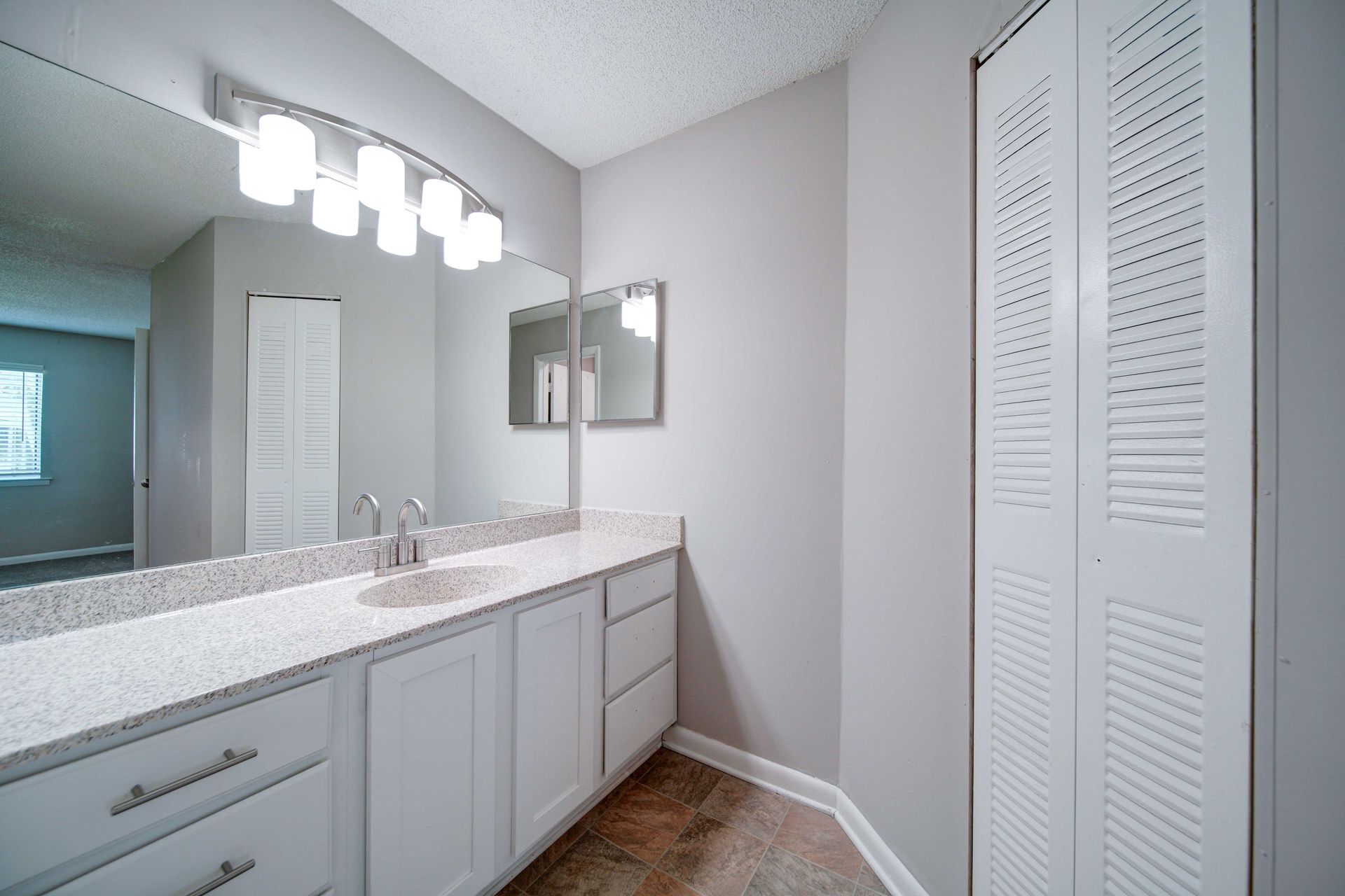 A bathroom with two sinks , a mirror and a closet.