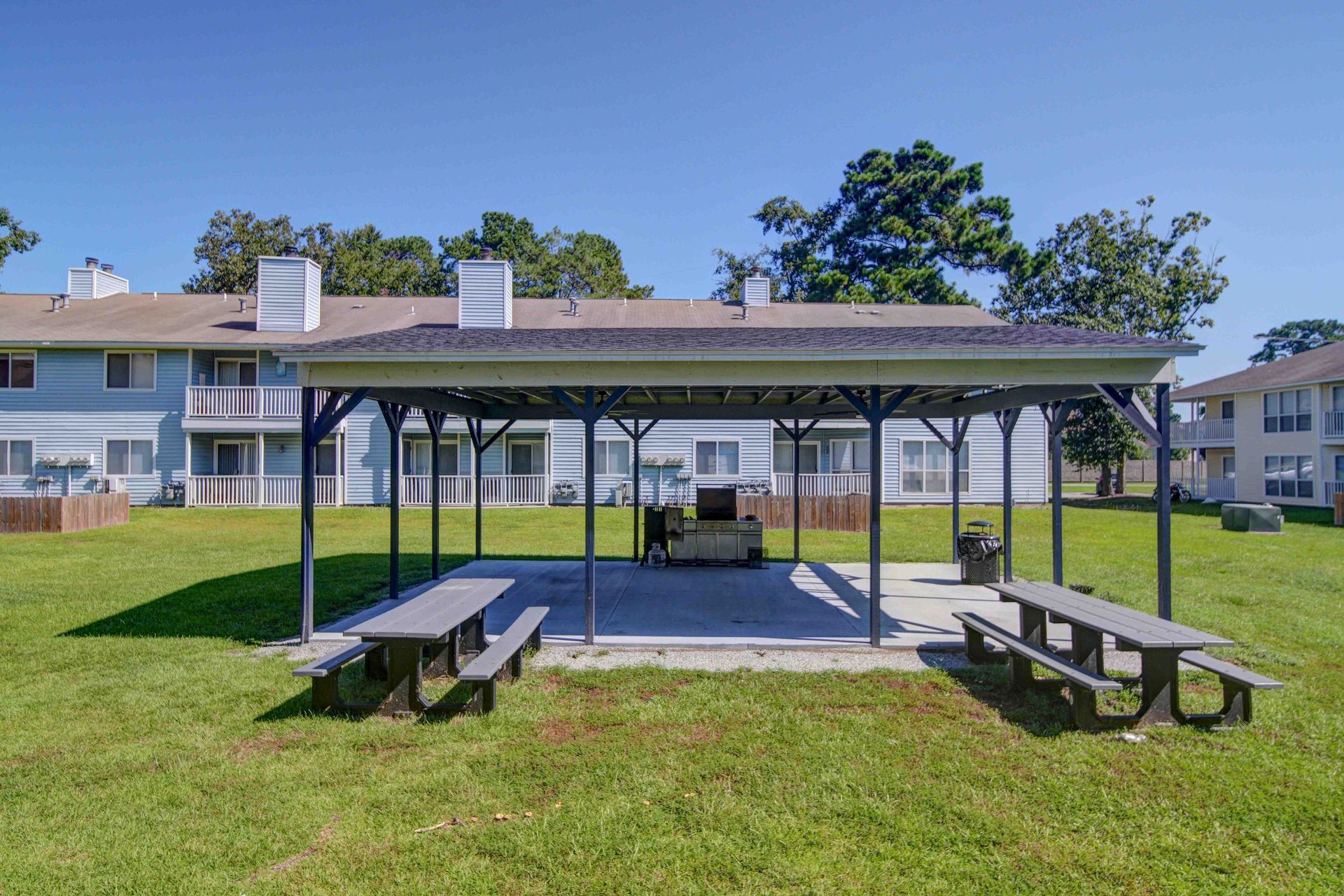 A picnic area with tables and benches in front of a building.