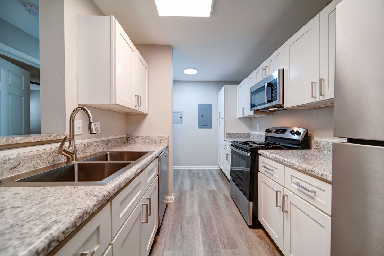 A kitchen with stainless steel appliances and granite counter tops.