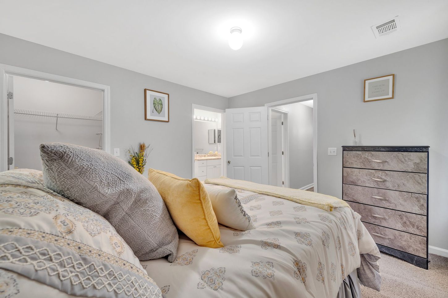 A bedroom with a large bed and a dresser.