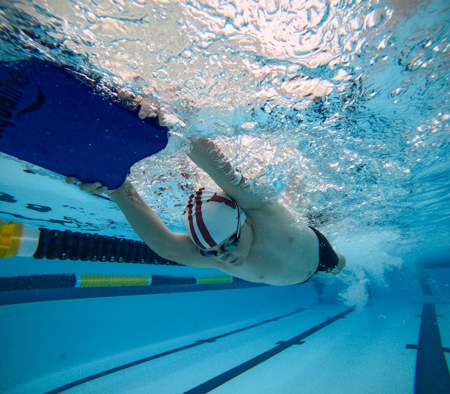 A man is swimming underwater in a swimming pool